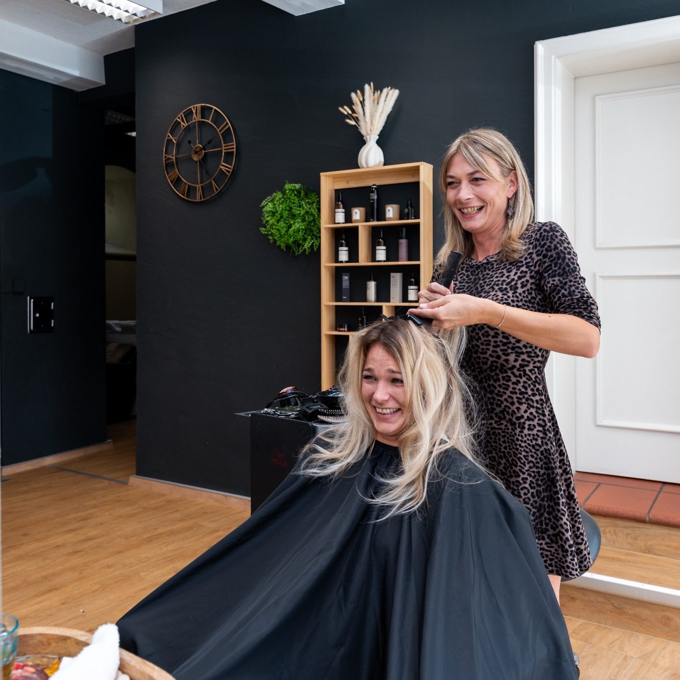 Friseurmeisterin Elly Friseurin stylt das Haar einer Kundin in einem modernen Salon.